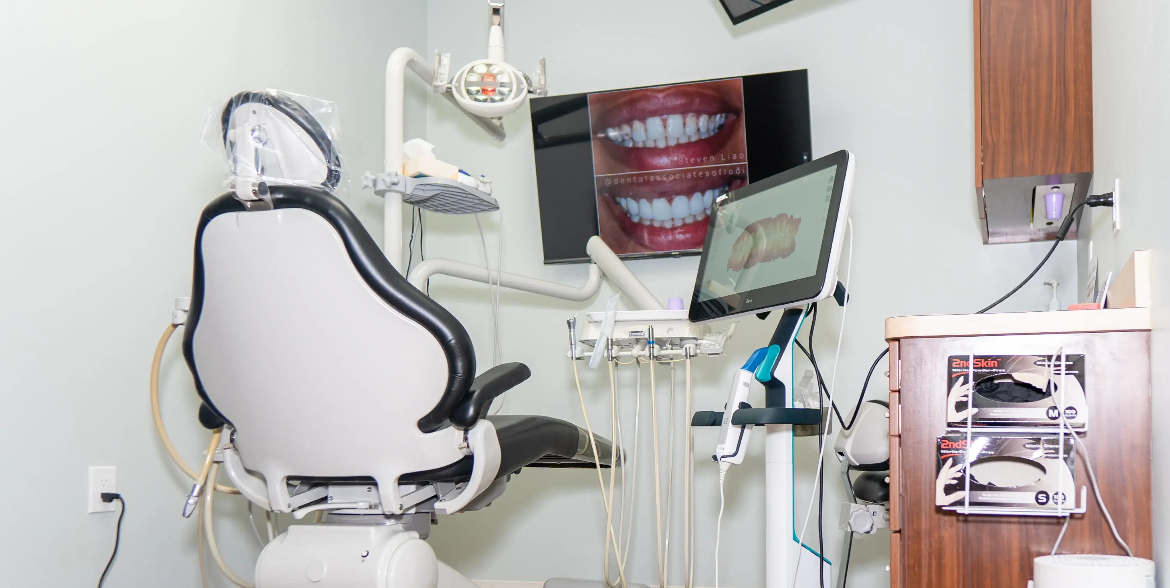 A treatment room at Dental Associates of Lodi, with a dental chair and digital imaging screens.