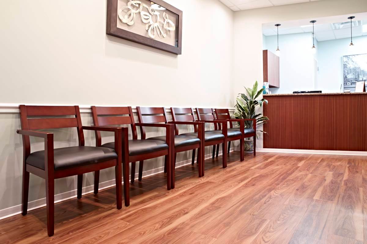 six wood chairs in waiting area of dental office